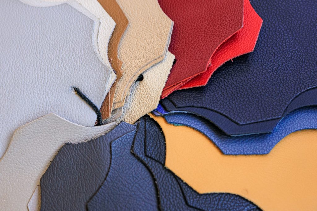 Samples of natural, textured, multi-colored leather. Top view. Industry fabric background.